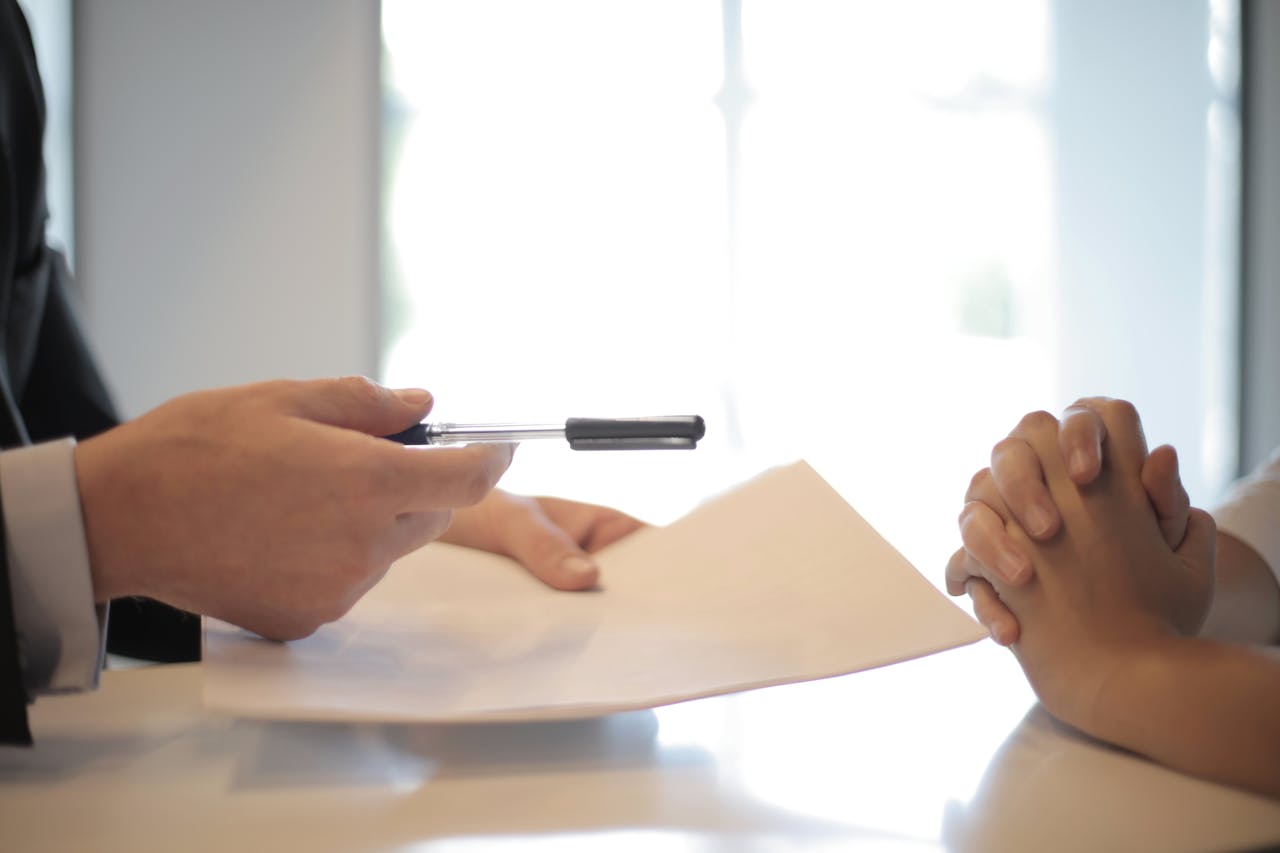 about-us Close-up of a contract signing with hands over documents. Professional business interaction.
